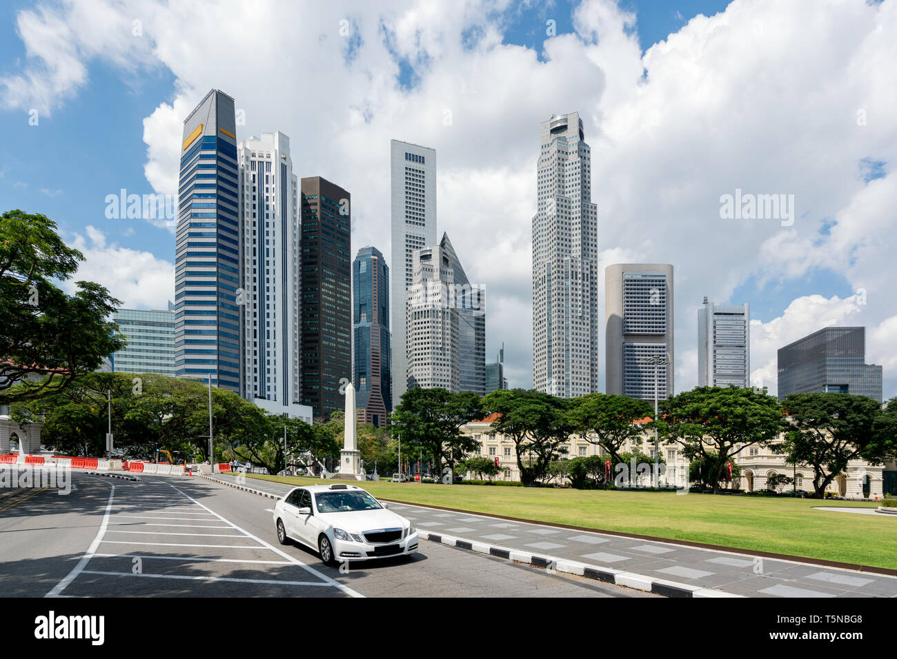 Taxi guida in strada nel centro cittadino di Singapore Singapore con la costruzione di grattacieli in background. Asia. Foto Stock