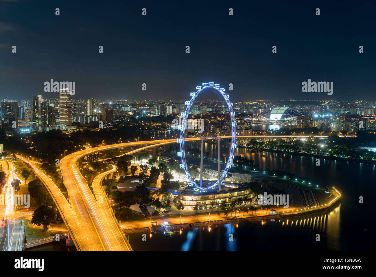 Vista aerea del Singapore Flyer e città in notturna a Singapore, in Asia. Foto Stock