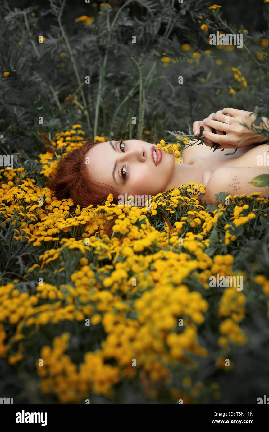 Ritratto di una ragazza distesa di fiori Foto Stock