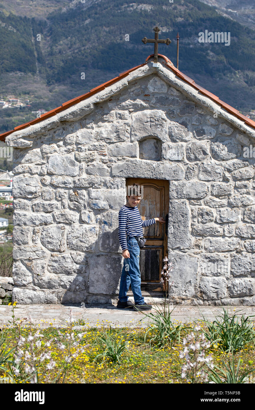 Ragazzo visita piccola cappella - Chiesa Ortodossa Serba santuario. Architettura sacrale - Ljesevici / Montenegro. Foto Stock