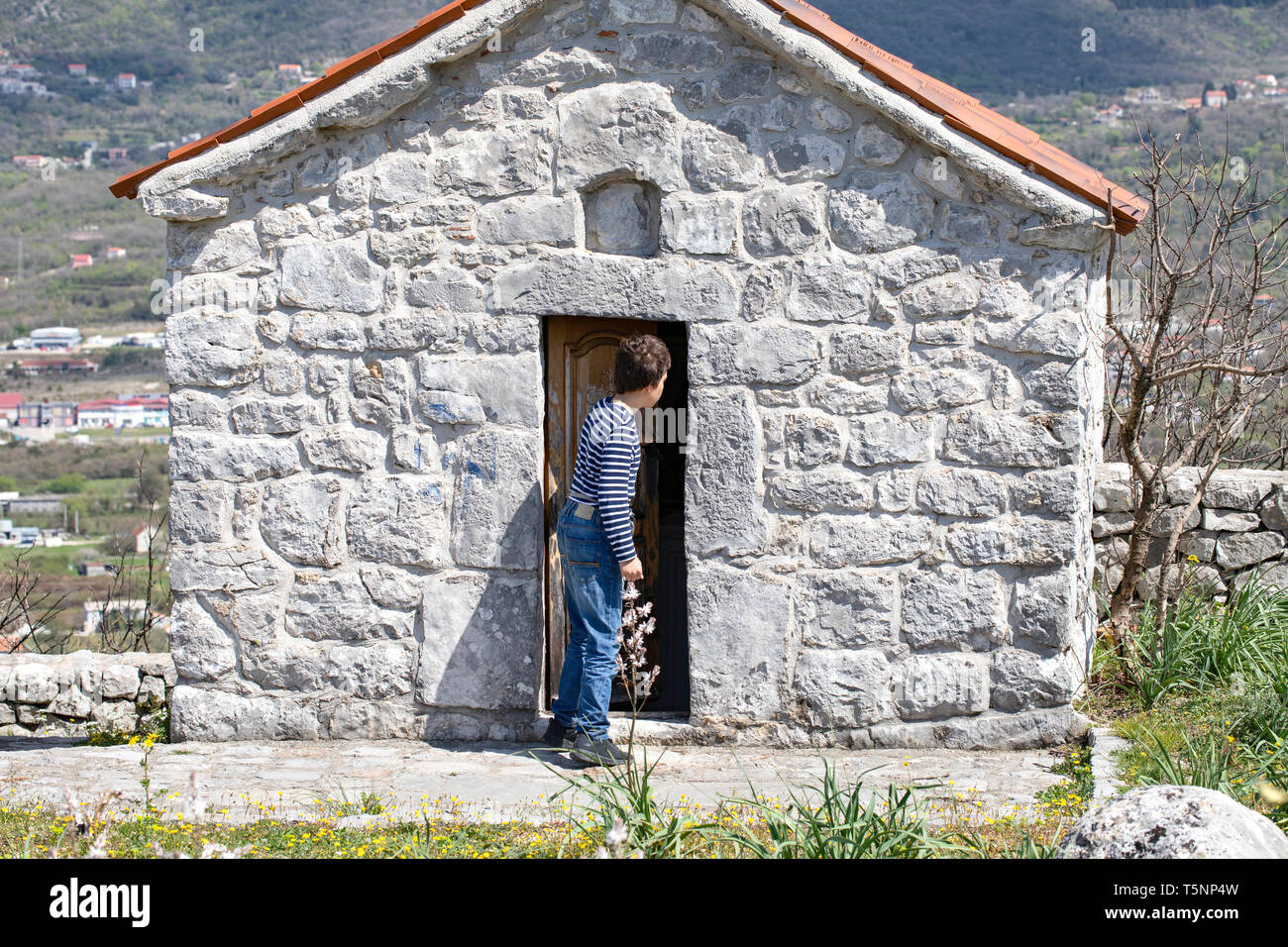 Ragazzo visita piccola cappella - Chiesa Ortodossa Serba santuario. Architettura sacrale - Ljesevici / Montenegro. Foto Stock