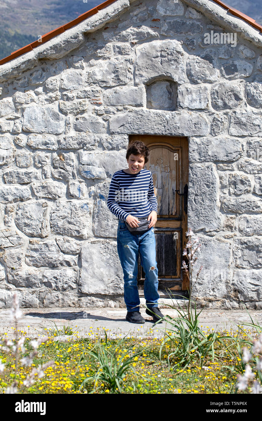 Ragazzo visita piccola cappella - Chiesa Ortodossa Serba santuario. Architettura sacrale - Ljesevici / Montenegro. Foto Stock