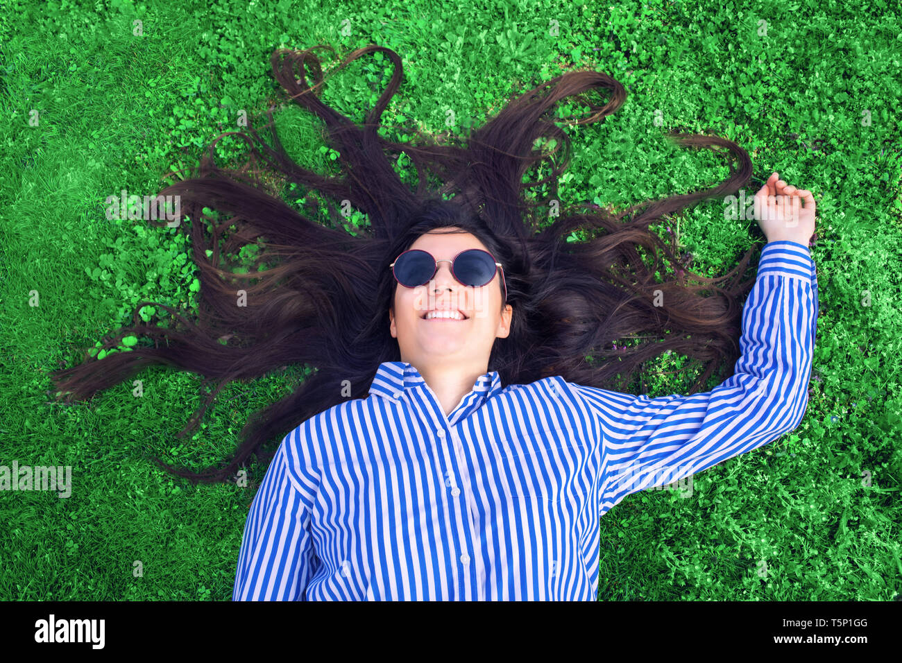 Giovane donna posa su erba verde Foto Stock