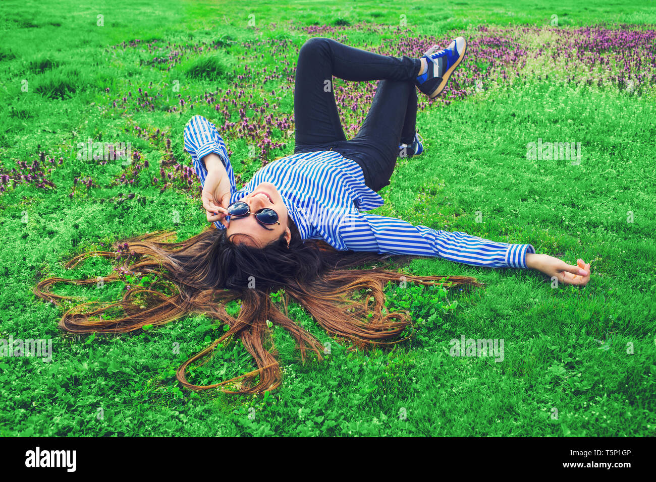 Giovane donna posa su erba verde Foto Stock