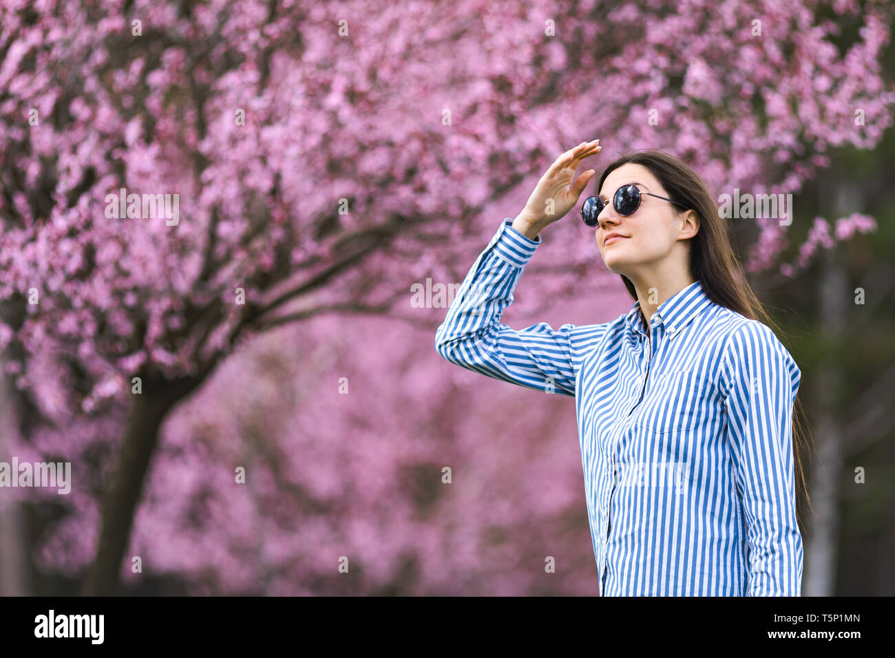 Bella giovane donna in dei ciliegi in fiore giardino Foto Stock