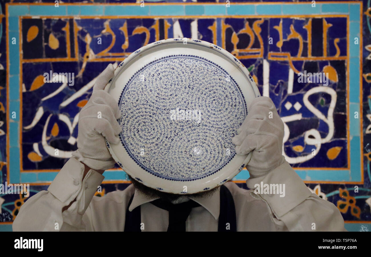Un tecnico gallery contiene una rara "Goldern Horn' ceramiche di Iznik piatto mentre in piedi di fronte ad un taglio Timurid piastrella Mosaico Pannello durante un'anteprima per la prossima Sotheby's Medio Orientale settimana d'arte vendita che si svolge il 30 aprile a Londra. Foto Stock