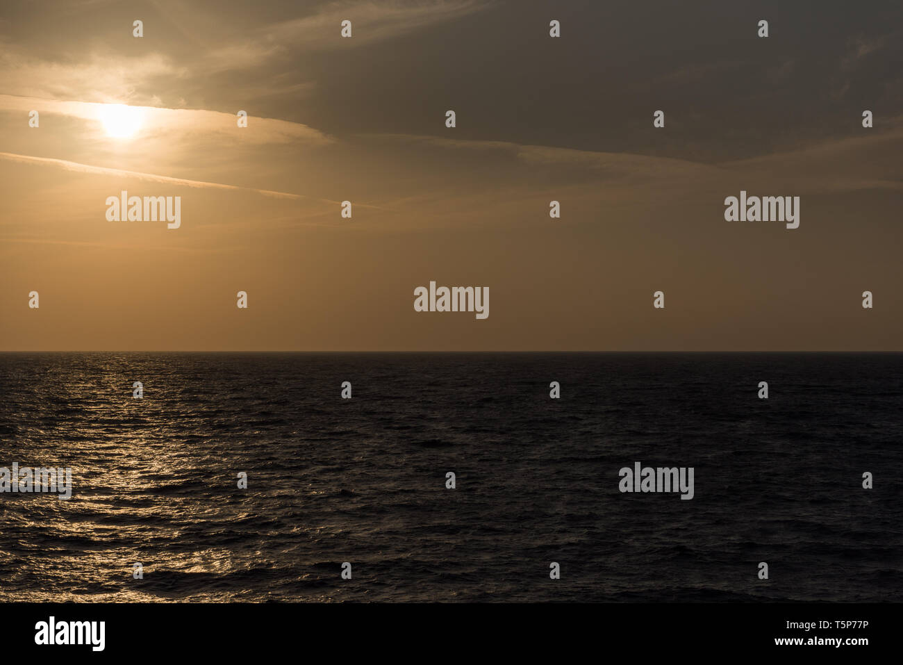 Arancione tramonto sopra il mare dalla nave Foto Stock