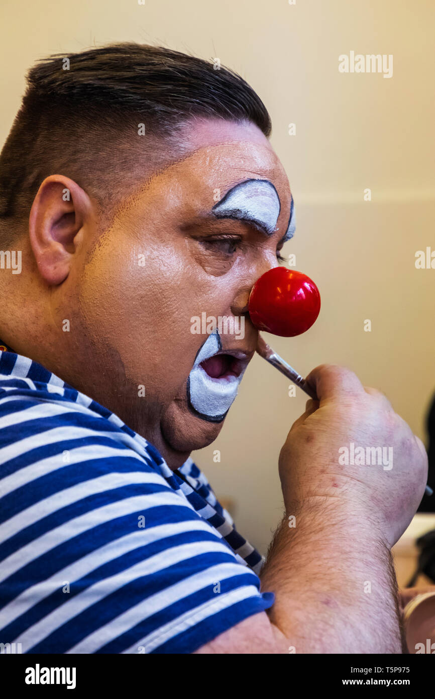 Inghilterra, Londra, l annuale Grimaldi clown servizio di chiesa in chiesa di Tutti i Santi, Haggerston, Clown con naso rosso di applicare il make-up Foto Stock