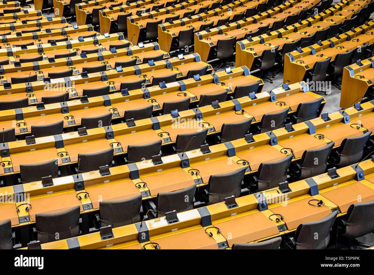 Angolo di alta vista sopra le righe di scrivanie in emiciclo vuoto, l'emiciclo del Parlamento europeo a Bruxelles in Belgio. Foto Stock