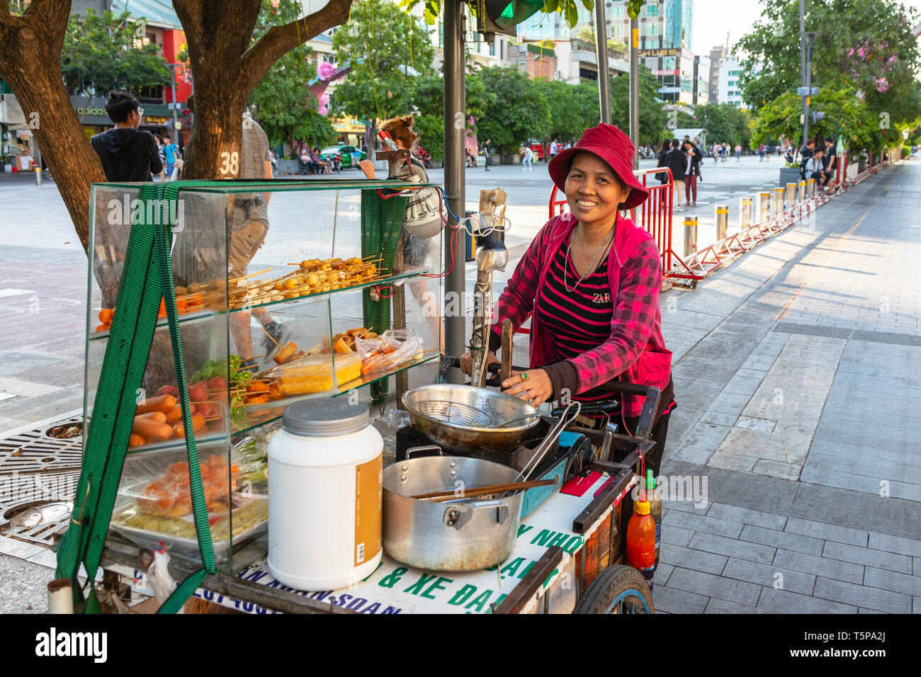 Donna vietnamita vendita di fast food da una cucina di strada, Ho Chi Minh City, a Saigon, Vietnam, Asia Foto Stock