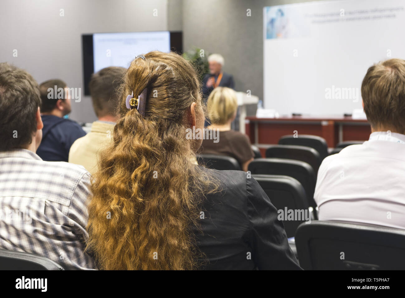 Donna d'affari e persone in ascolto sulla conferenza. L'immagine orizzontale con copia spazio. Foto Stock