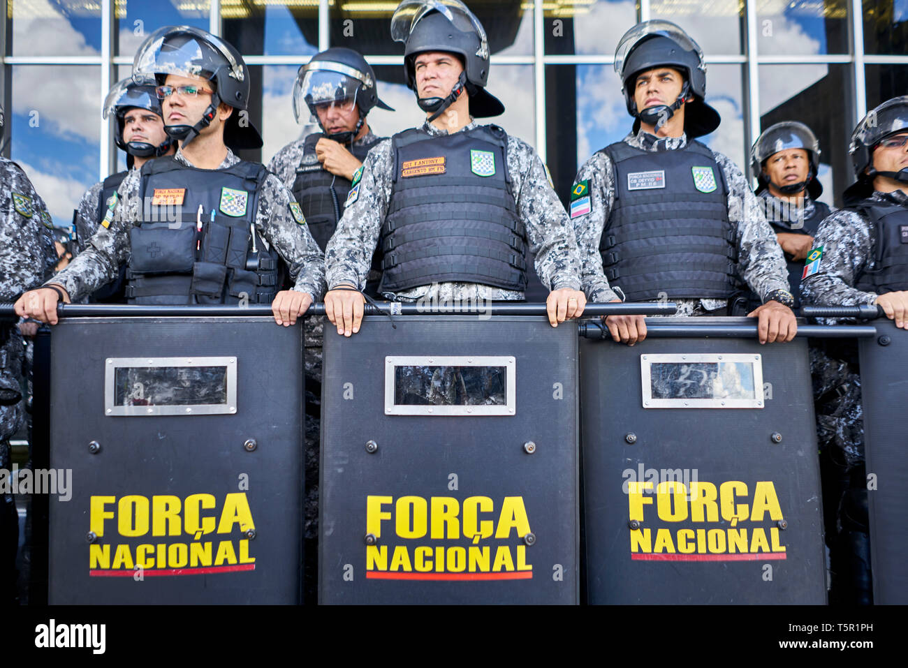 Brasilia, Brasile. 26 apr, 2019. La Força Nacional unità è bloccando l'ingresso al Ministero di Giustizia per ordine del presidente Bolsonaro durante la protesta indigena a Brasilia. Tra le altre cose, gli indigeni protesta per la protezione del loro habitat. Presidente Bolsonaro vuole ridurre la protezione della regione amazzonica e utilizzare la foresta pluviale più economicamente. Credito: Pablo Albarenga/dpa/Alamy Live News Foto Stock