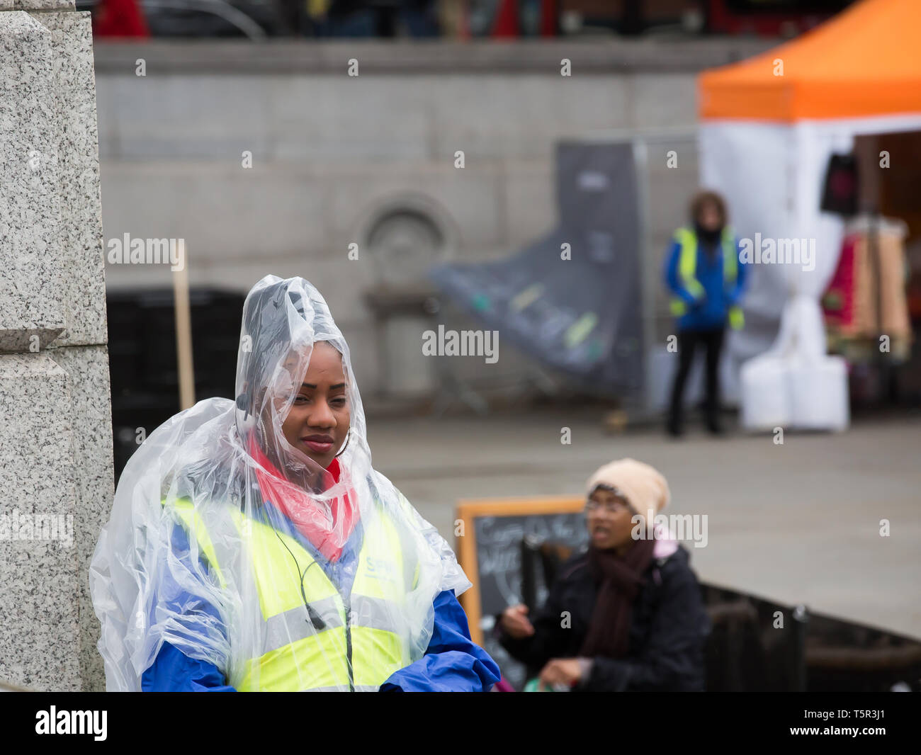 Londra, Regno Unito. 27 apr, 2019. Un membro del personale di sicurezza indossa un poncho come protezione contro la pioggia a Vaisakhi festival, in Trafalgar Square,Londra. Credito: Keith Larby/Alamy Live News Foto Stock