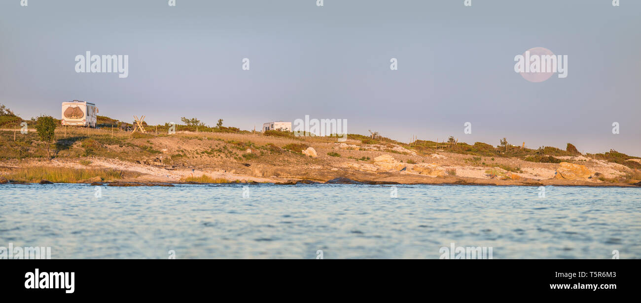 Campeggio in natura, camper parcheggiato su una spiaggia in un bellissimo paesaggio con la luna piena sorge dietro, Gotland, Svezia e Scandinavia Foto Stock