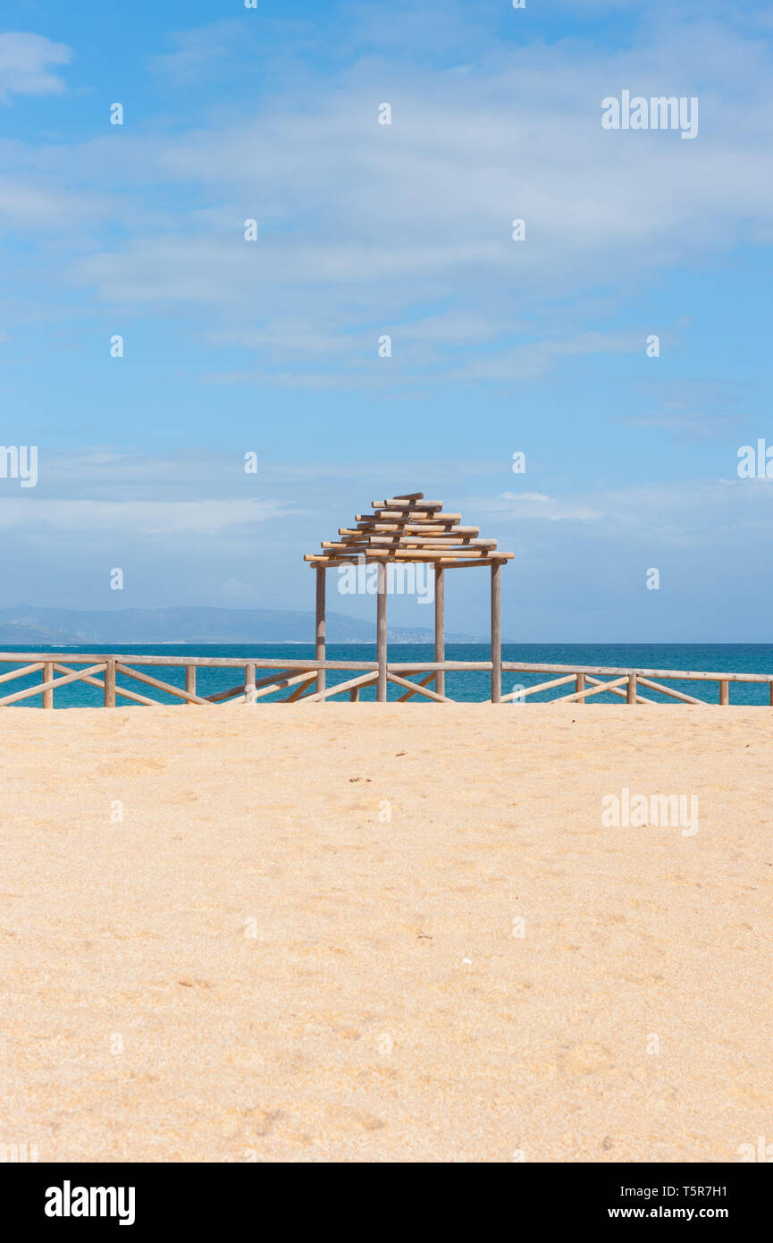 Struttura in legno su vuoto spiaggia sabbiosa con il blu del cielo e del mare Foto Stock