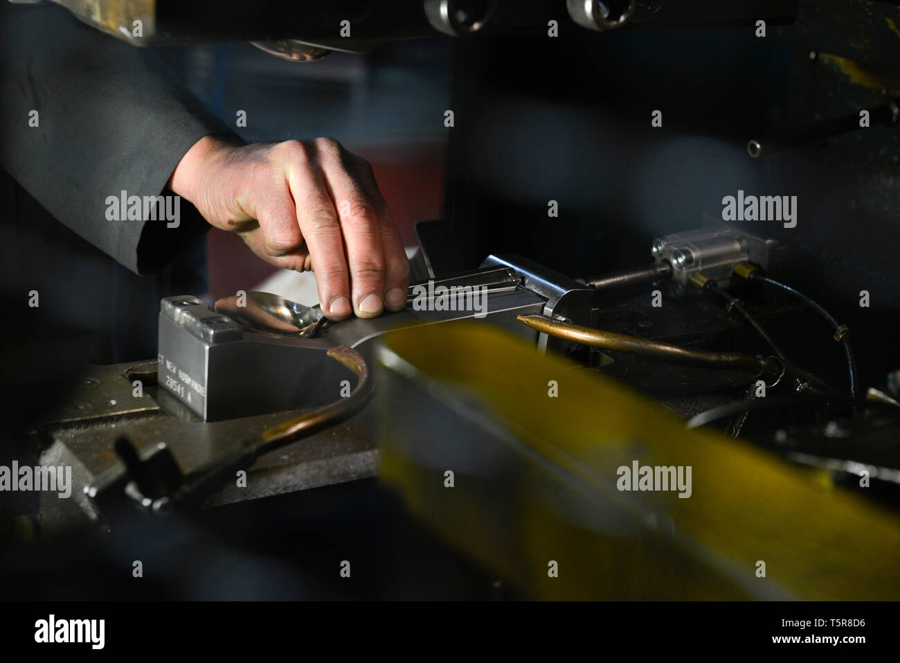 Guy Degrenne nella factory di Vire (Normandia, a nord-ovest della Francia), specializzata nella posateria e argenteria. Acciaio inossidabile argenteria workshop: lavoratore usi Foto Stock