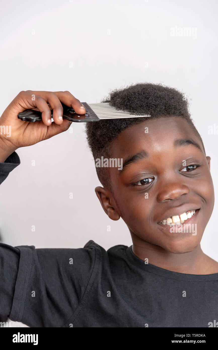 Andover, Hampshire, Inghilterra, Regno Unito. Aprile 2019. Bambino di nove  anni con capelli ricci tenendo un dente largo afro il pettine per i capelli  Foto stock - Alamy