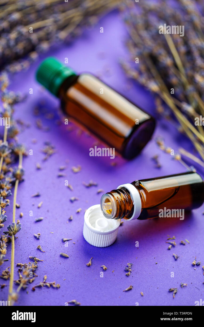 Bottiglie di lavandula olio essenziale, mazzo di essiccato viola i fiori di lavanda. Olio essenziale di lavanda e fiori Foto Stock