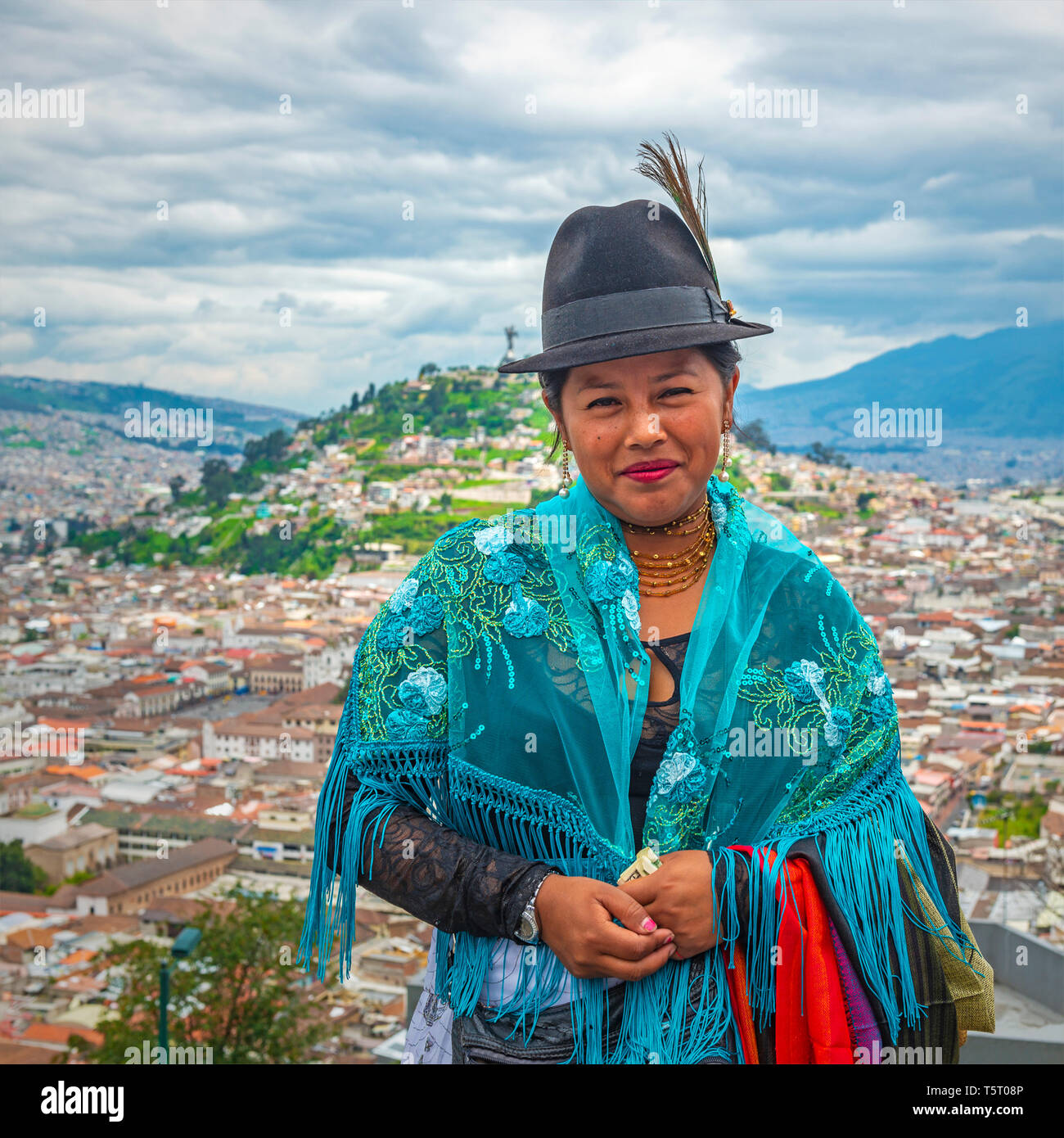 Ritratto di un sorridente indigeno di Otavalo commessa tessile di fronte al centro storico della città di Quito per la Cordigliera delle Ande, Ecuador. Foto Stock