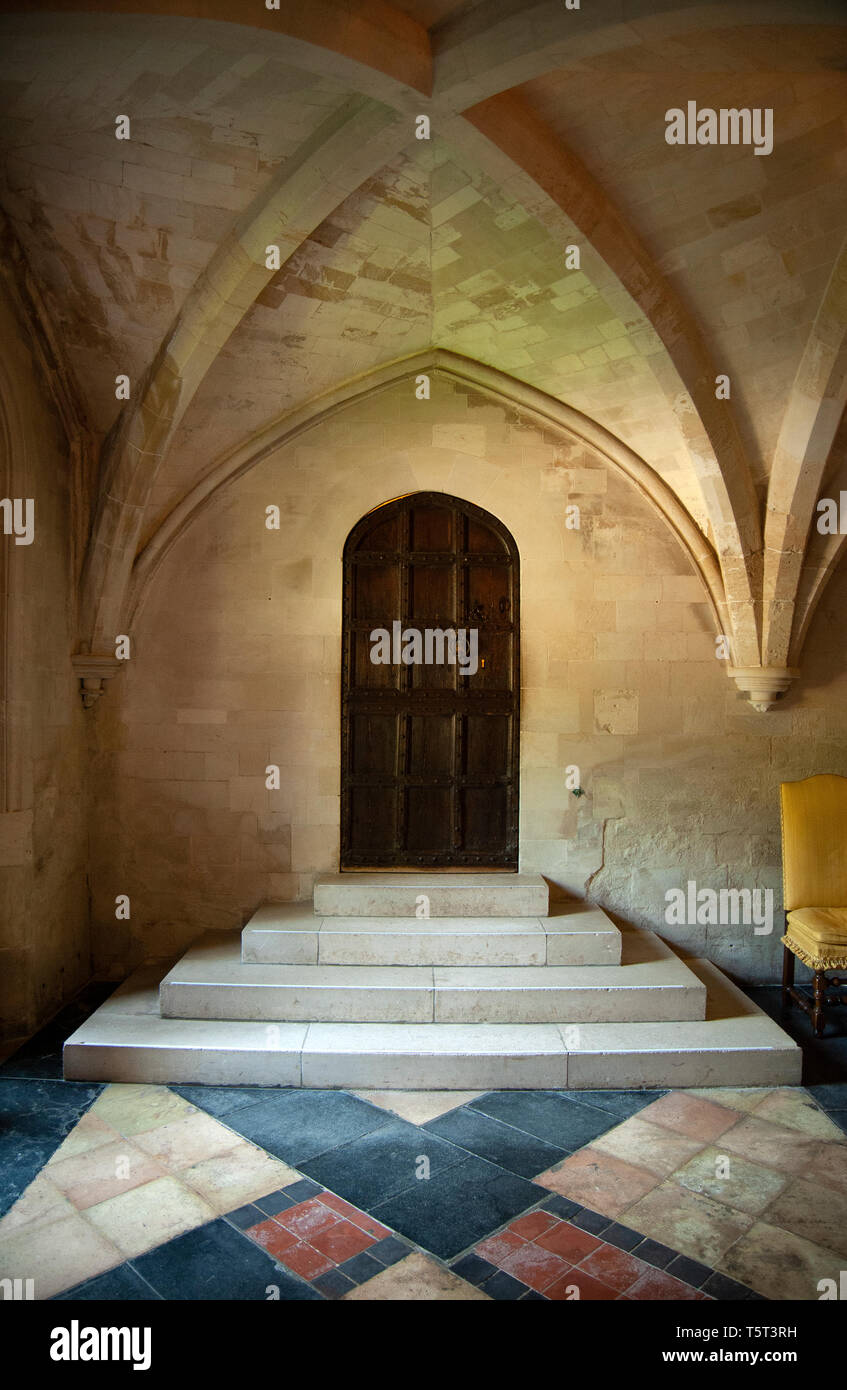 Gradini in pietra e una porta di legno nel medioevo sala da pranzo a Anglesey Abbey, lode, Cambridgeshire. Essa era parte dell'originale convento agostiniano. Foto Stock