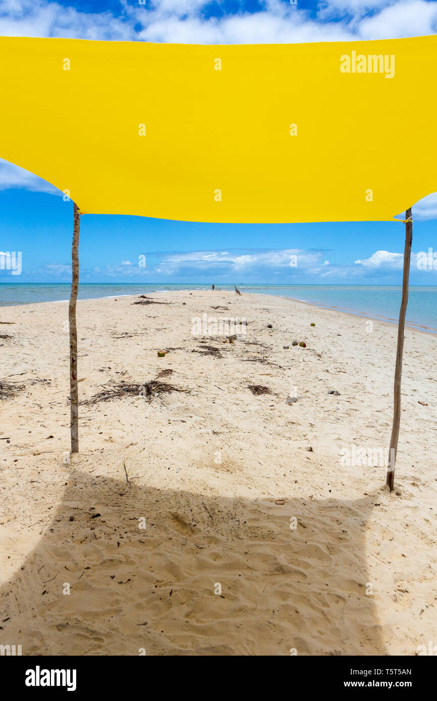 Bellissima spiaggia vista dall'interno della tenda gialla sulla soleggiata giornata estiva. Mare e cielo blu in background. Concetto di vacanze, la pace e il relax.Bahia Foto Stock