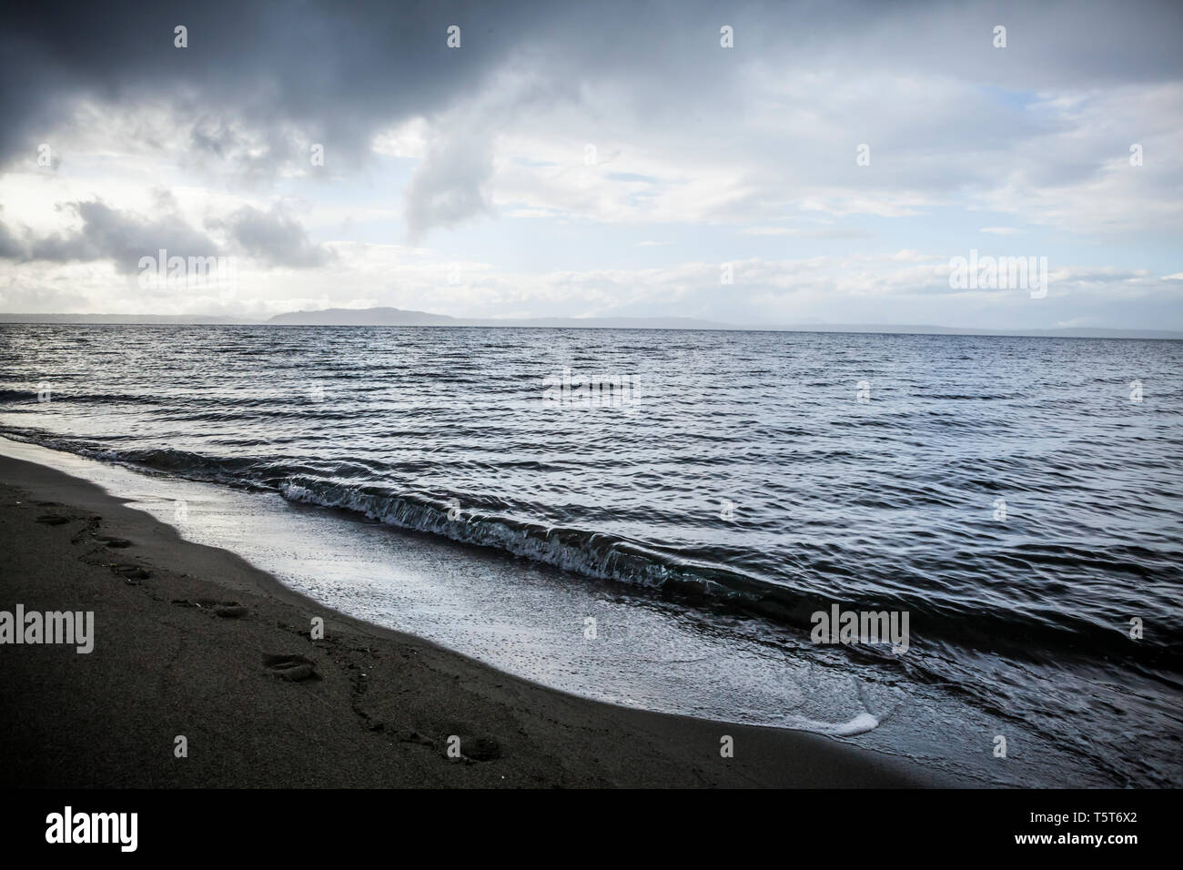 Una tempesta si cancella lontano oltre il Puget Sound e Alki Beach, a ovest di Seattle, Washington, Stati Uniti d'America. Foto Stock