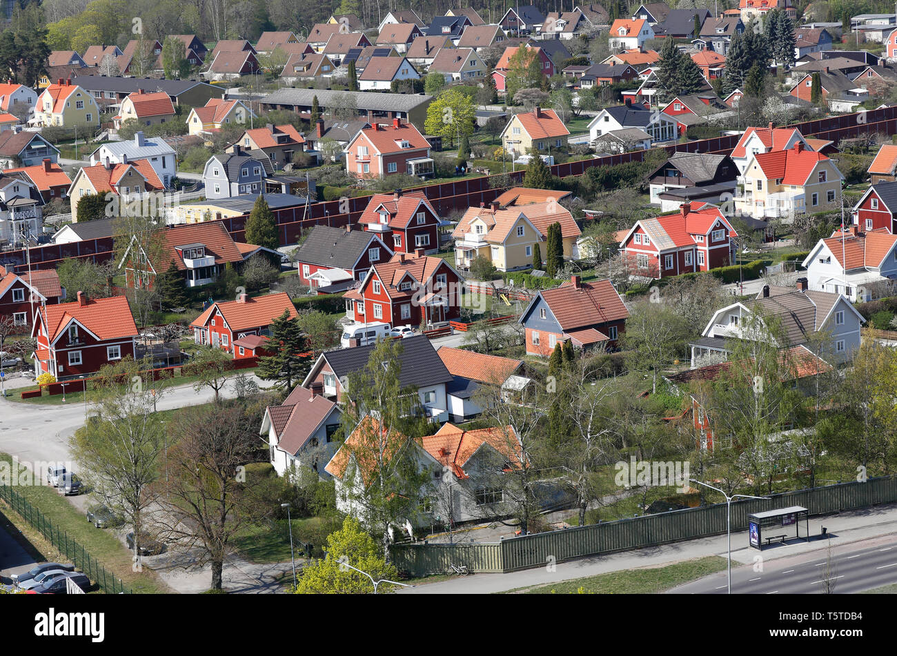 Orebro, Svezia - 19 Aprile 2019: veduta aerea di una zona residenziale con singola famiglia di edifici con una ferrovia con barriere antirumore. Foto Stock