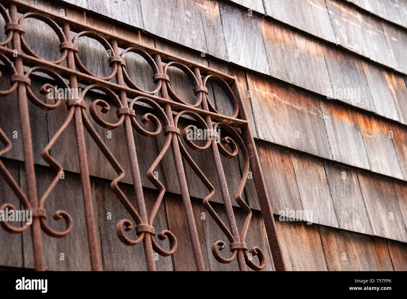 Legno stagionato shingle schierata e rusty ferro battuto porta di metallo Foto Stock