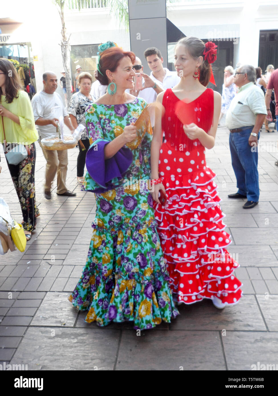 Locali spagnoli donne abbigliate con vestiti tradizionali abiti di flamenco frequentando la Feria del Rosario. Un comunity annuale fiera a Fuengirola, Costa del sol, Foto Stock
