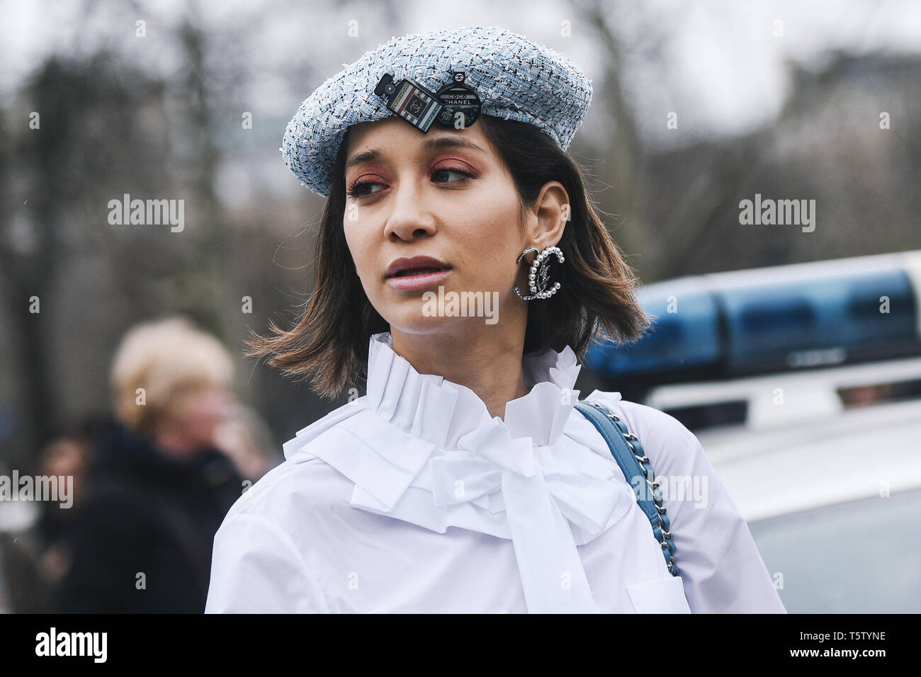 Parigi, Francia - 5 Marzo 2019: Street style - donna che indossa indossa  una camicia bianca, luce pantaloni blu, nero tacchi, azzurro hat e stampato  Chanel ba Foto stock - Alamy