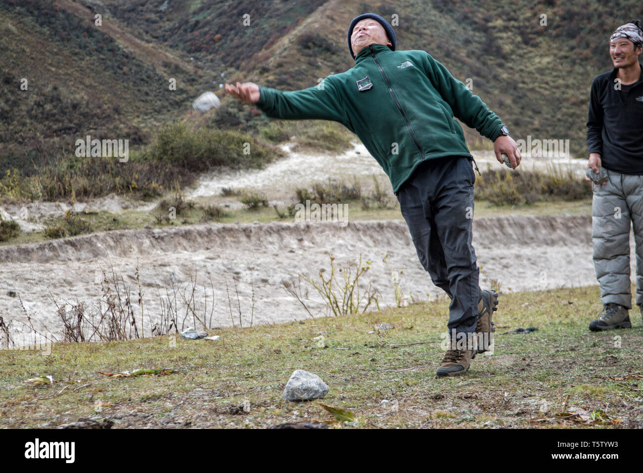 Gli uomini che giocano dego (tradizionale gioco bhutanesi), Chozo, Lunana Gewog, Gasa distretto, Bhutan Foto Stock