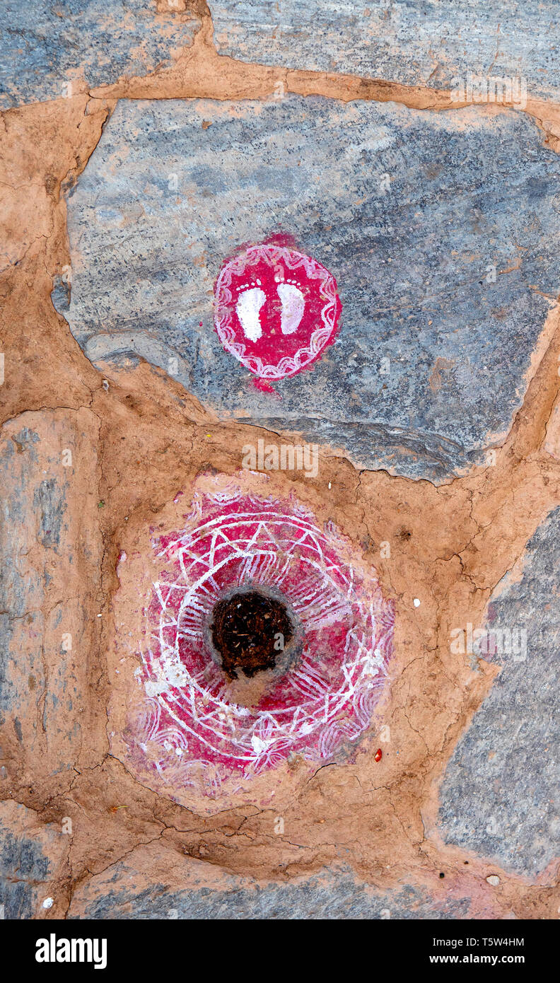 Orme della dea Lakshmi in bianco su un rosso roundel portando la ricchezza e la buona fortuna per la casa nel villaggio Supi in Uttarakhand Himalaya Foto Stock