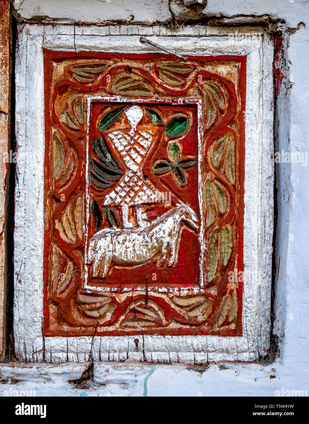 Dipinto scolpito sul pannello della porta dell'uomo a cavallo su la casa principale in Supi villaggio nella valle di Saryu dell'Uttarakhand Himalaya India del nord Foto Stock