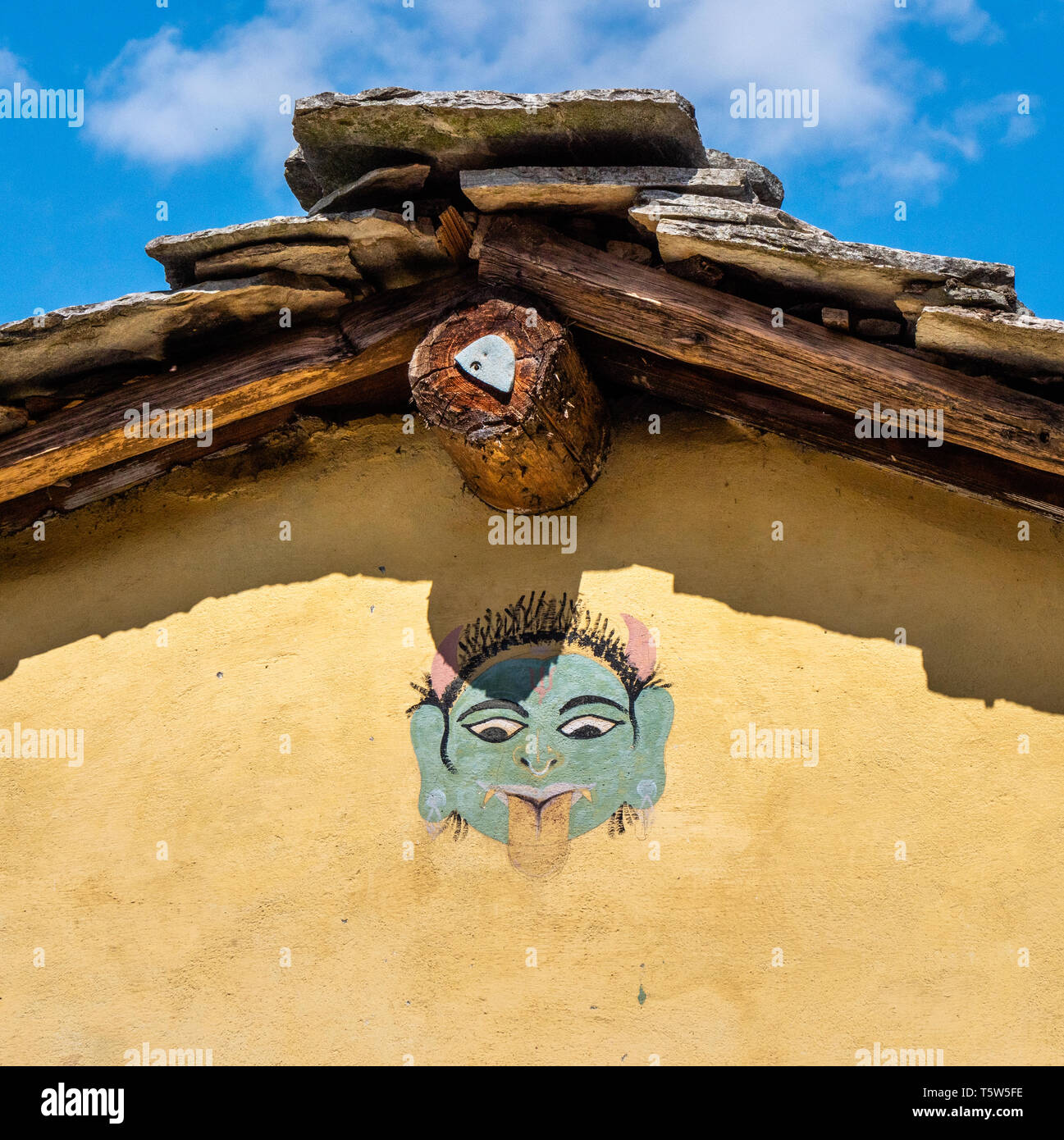 Verniciatura del dio indiano Thali con linguetta sporgente sotto il tetto di una casa in Dhurr In Pindaro Valle di Uttarakhand India del Nord Foto Stock