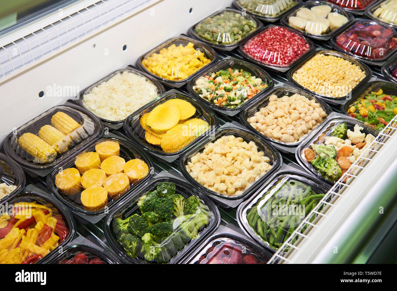 Refrigerate ortaggi in contenitori di plastica sul banco di negozio Foto Stock