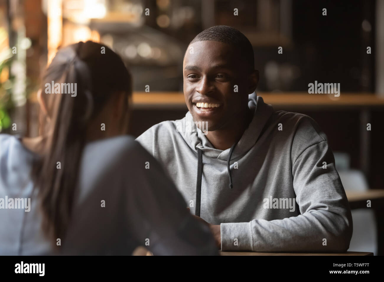Nero allegro guy chiacchierando con la ragazza durante lo speed dating Foto Stock