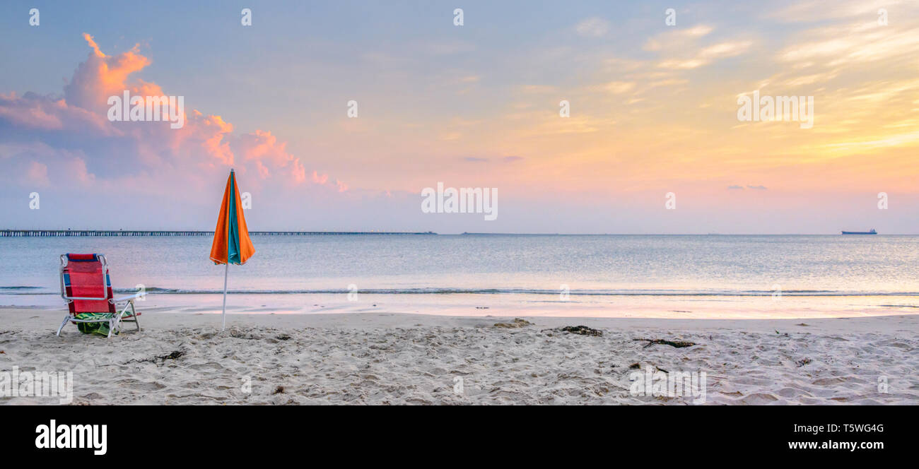 Spiaggia di sdraio e ombrelloni da sole sulla spiaggia. Chesapeake Bay Bridge e Tunnel in background Foto Stock