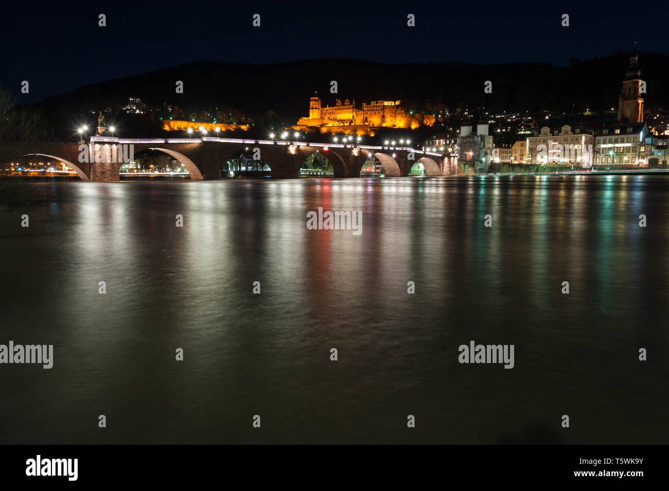 Heidelbergs castello illuminato di notte con la città vecchia e il ponte sul fiume Neckar in primo piano cattura mystic riflessi di luci della città Foto Stock