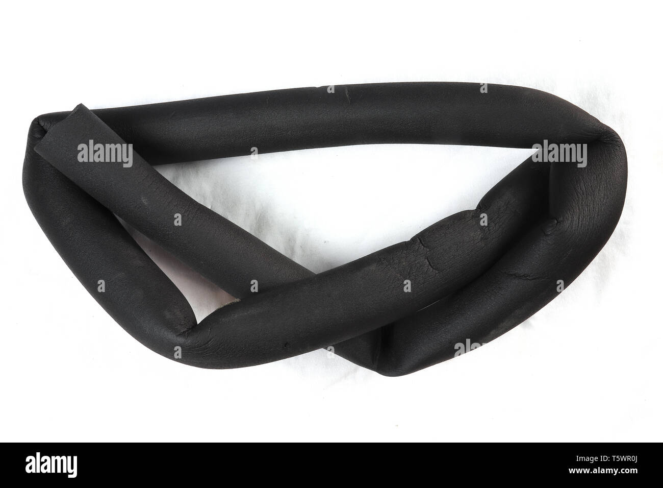 Pezzo di annodamento di un tubo isolante, isolamento termico tubo di espanso. PE polietilen schiuma tubo di isolamento, isolato su sfondo nero. , Alta resoluti Foto Stock