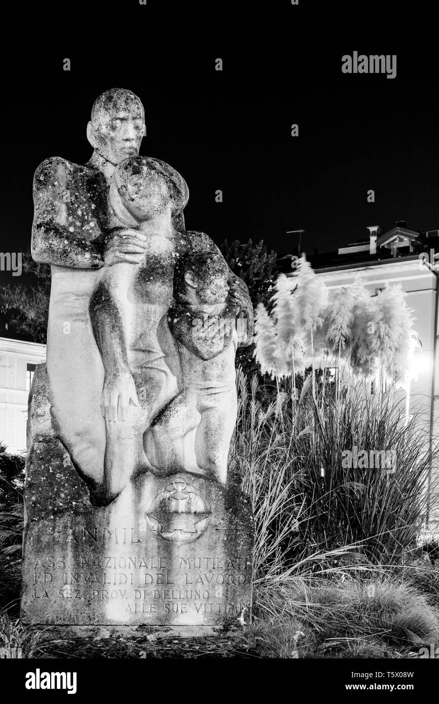 Antica figura in bianco e nero di un abbraccio famiglia su una piazza italiana di notte Foto Stock