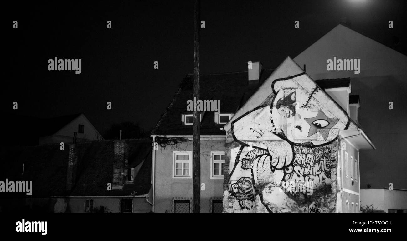 Vista frontale di una casa urbana con una massiccia graffiti sulla facciata in una grande città di notte Foto Stock
