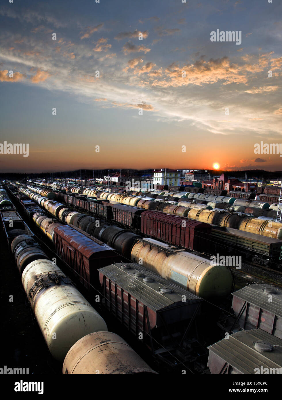 Automobili della ferrovia su una stazione ferroviaria. Trasporto merci. Lavoro di industria. Scena urbana. Bel tramonto. Foto Stock