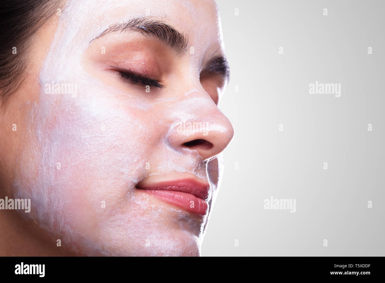 Bella giovane donna viso applicare la maschera per il viso Foto Stock