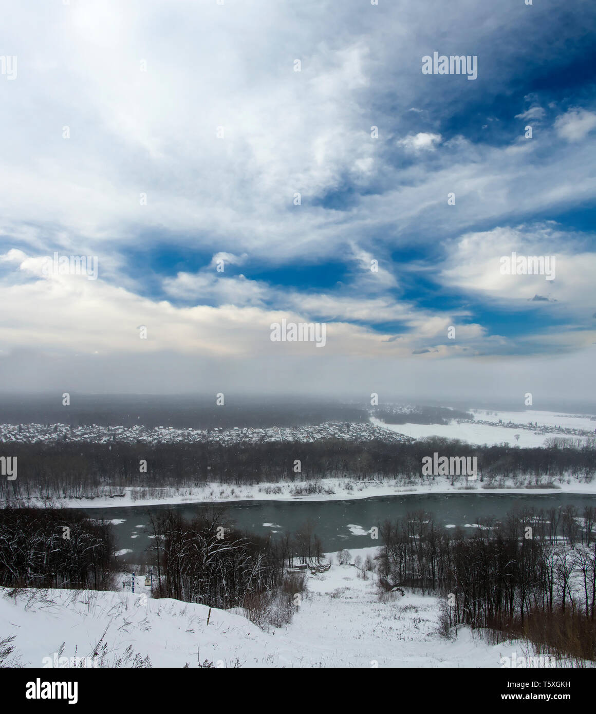 Paesaggio invernale. Grigio boschi innevati e cielo blu con nuvole bianche. Fiume Freddo Foto Stock