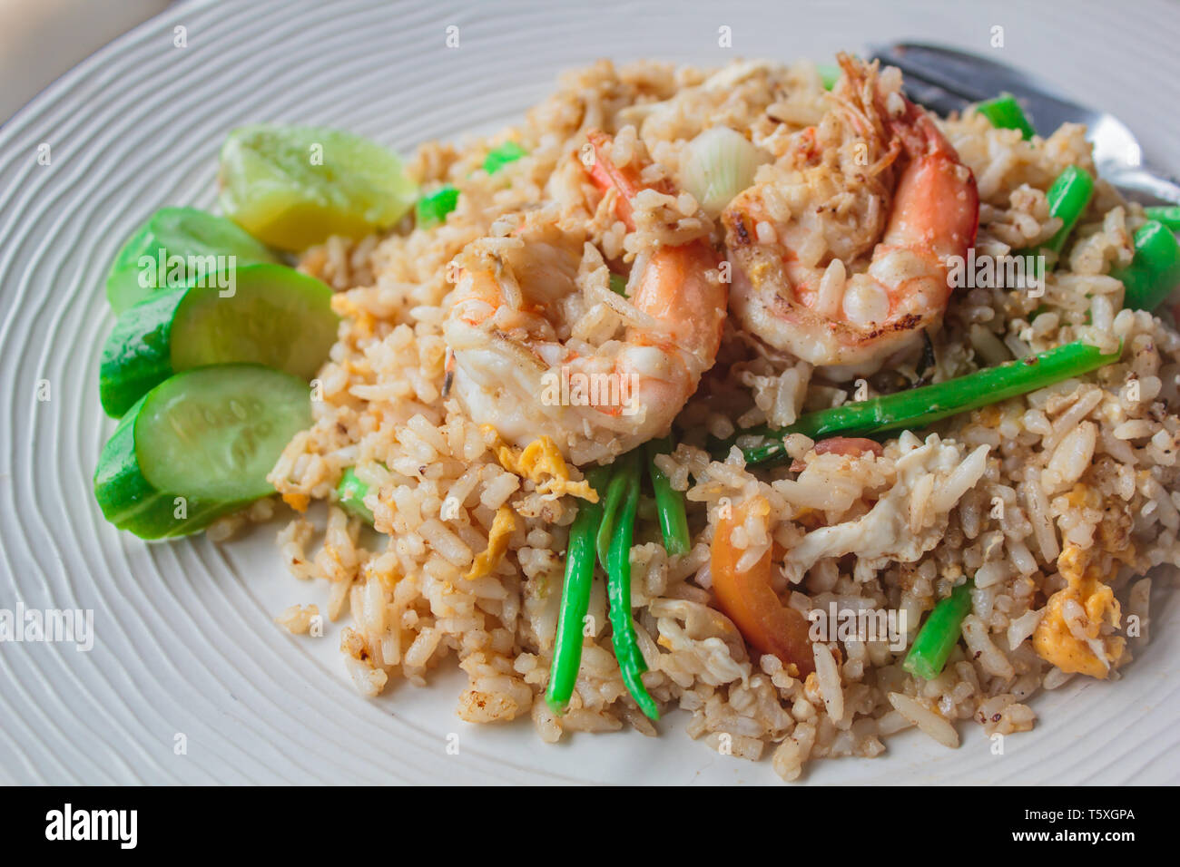 Riso fritto con gamberetti sul piatto bianco al ristorante. Foto Stock
