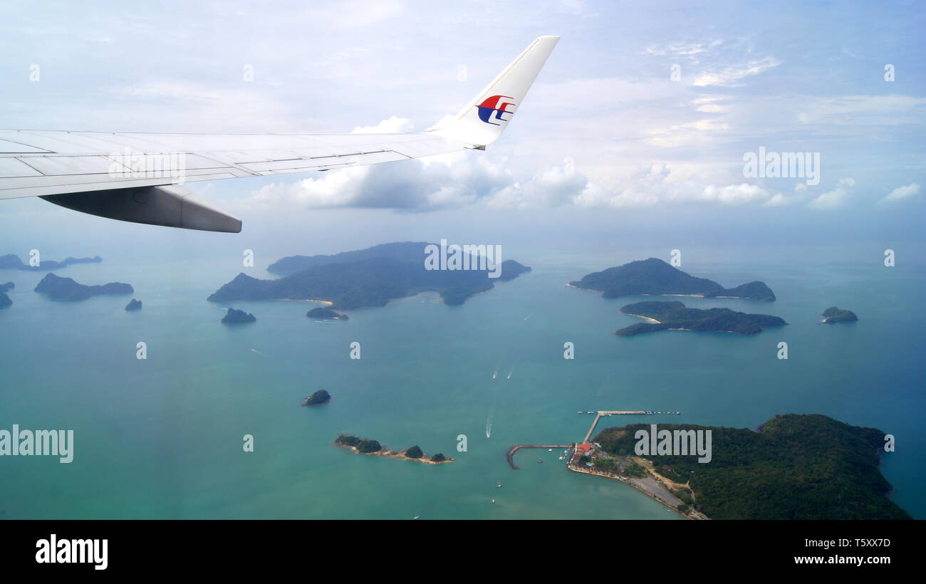 KEDAH, Langkawi, Malesia - Aprile 11th, 2015: Scenario dalla finestra aereo vedendo l'ala del velivolo, il bianco delle nuvole, cielo blu e belle isole Foto Stock