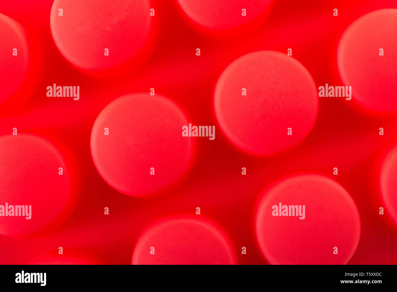Abstract in silicone di colore rosso a stampo di cioccolato. Metafora utensili da cucina, attrezzature di cucina, pasticceria, dolci stampo, rendendo dolce. Foto Stock