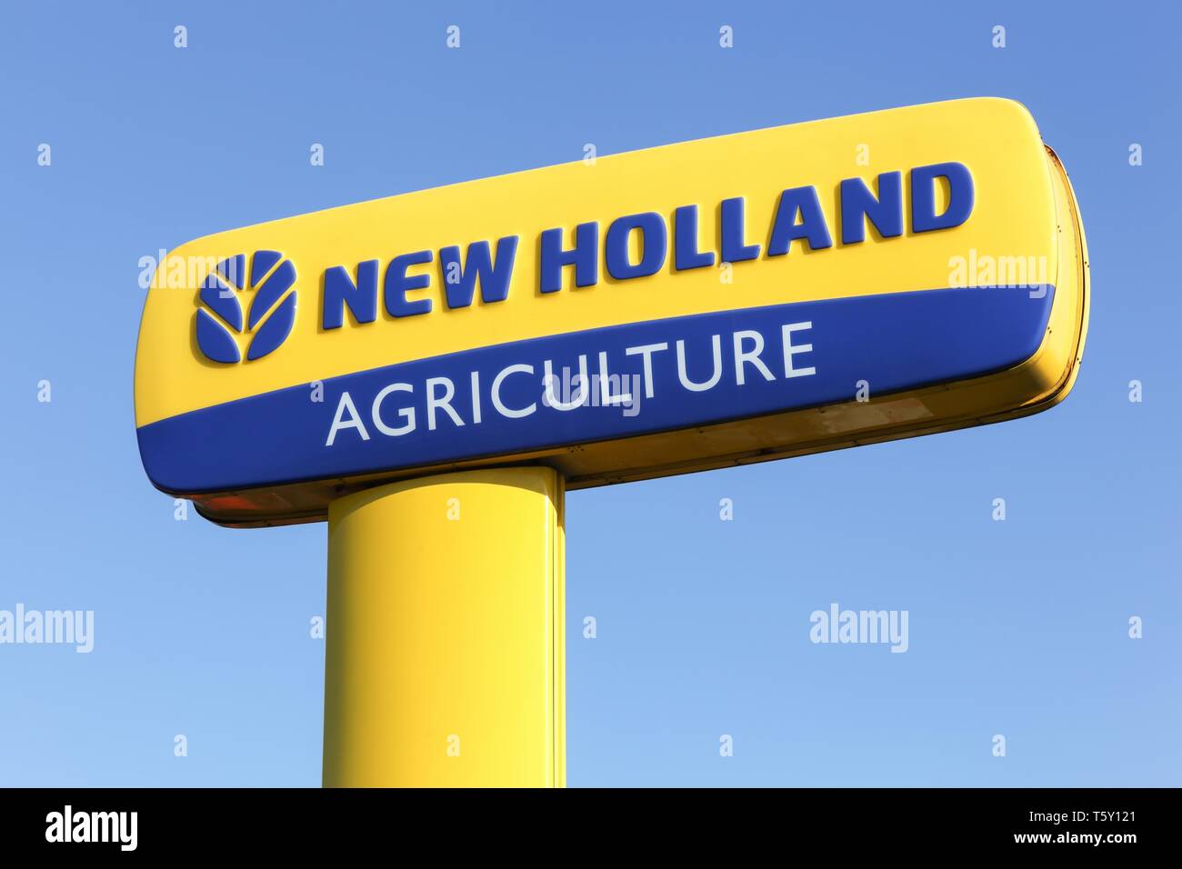 Hadsten, Danimarca - 5 Maggio 2018: New Holland Agriculture logo su un palo. New Holland è una marca di attrezzature agricole da fabbricati industriali di CNH Foto Stock