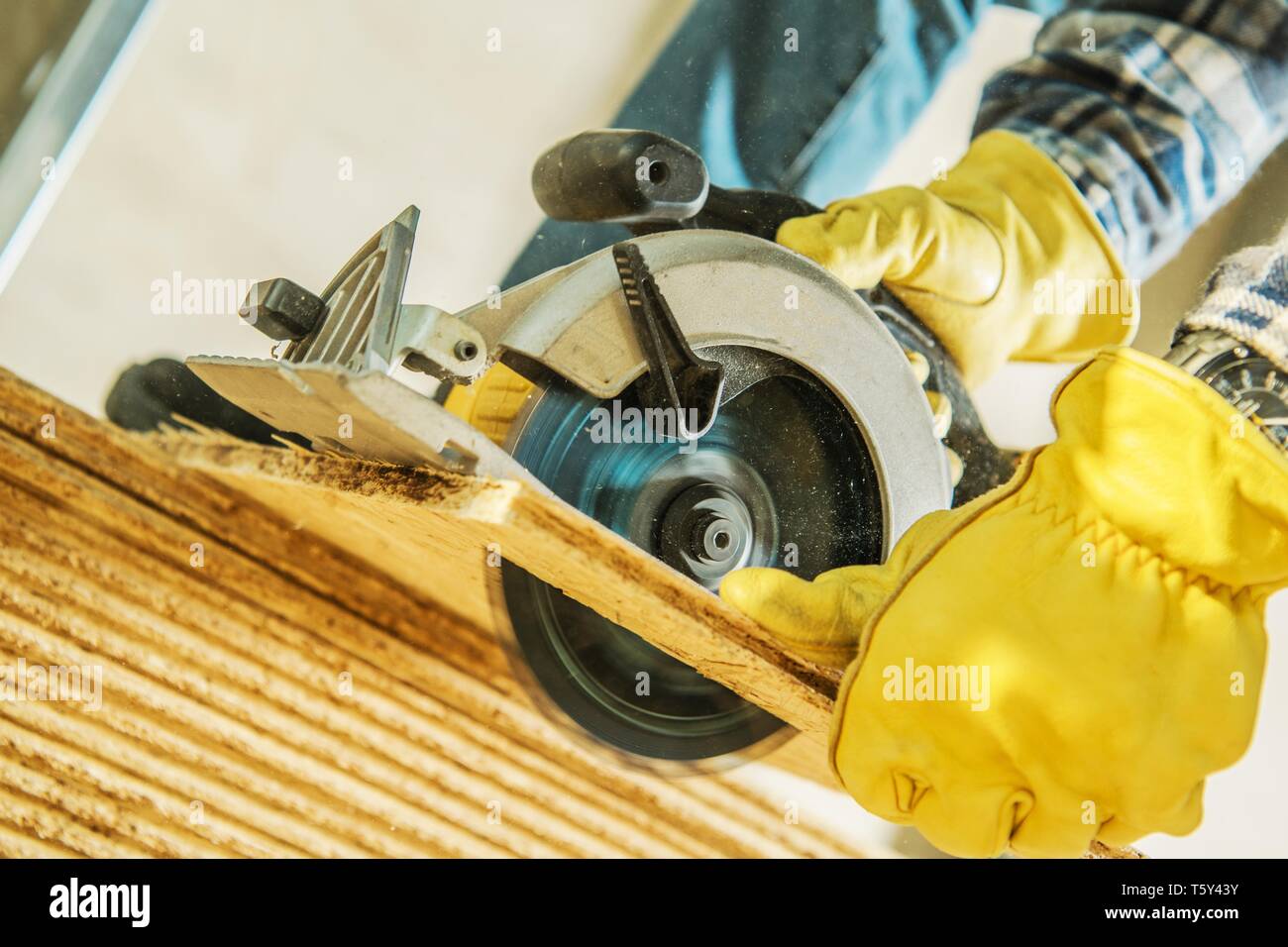 Sito in costruzione Power Tools. Lavoratore di compensato di taglio con sega circolare. Concetto industriale. Foto Stock