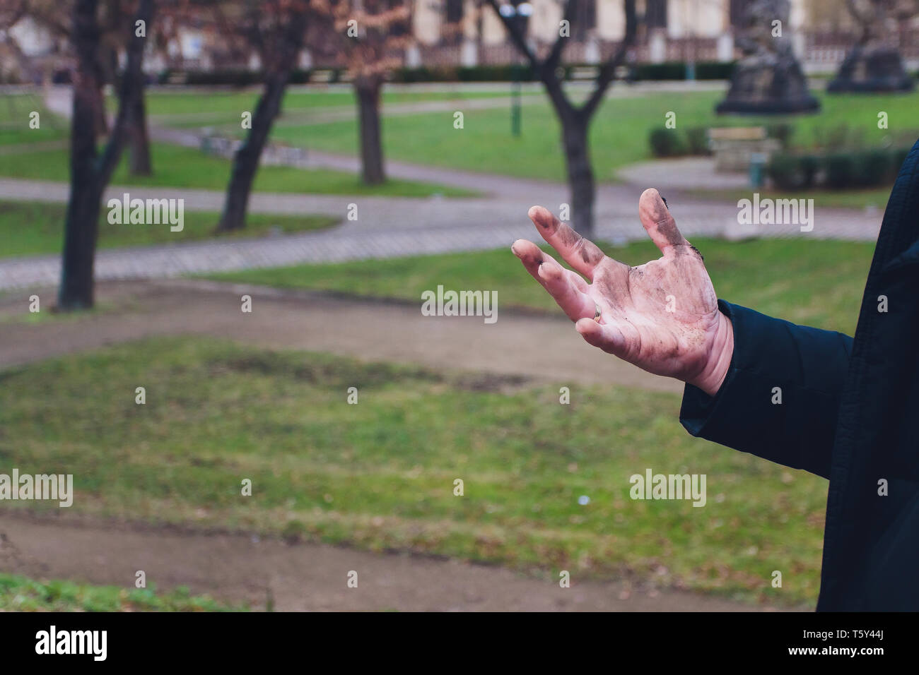 Mano sporca. Sporco mano di uomo sulla sabbia. Foto Stock